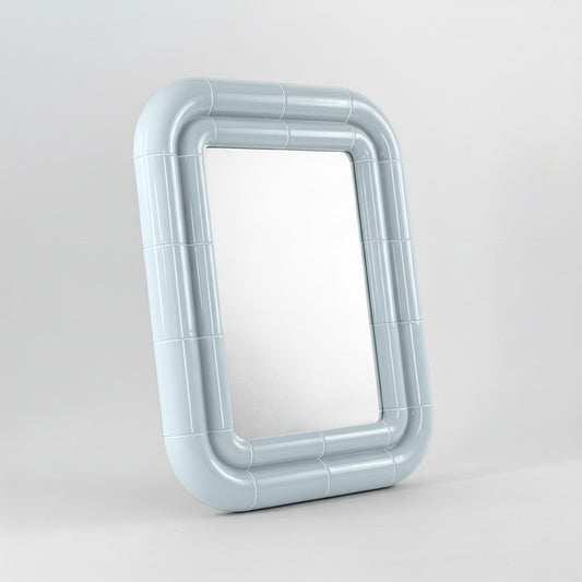 Portalito mirror in Ice Blue, sculptural tubular frame, angled view highlighting depth