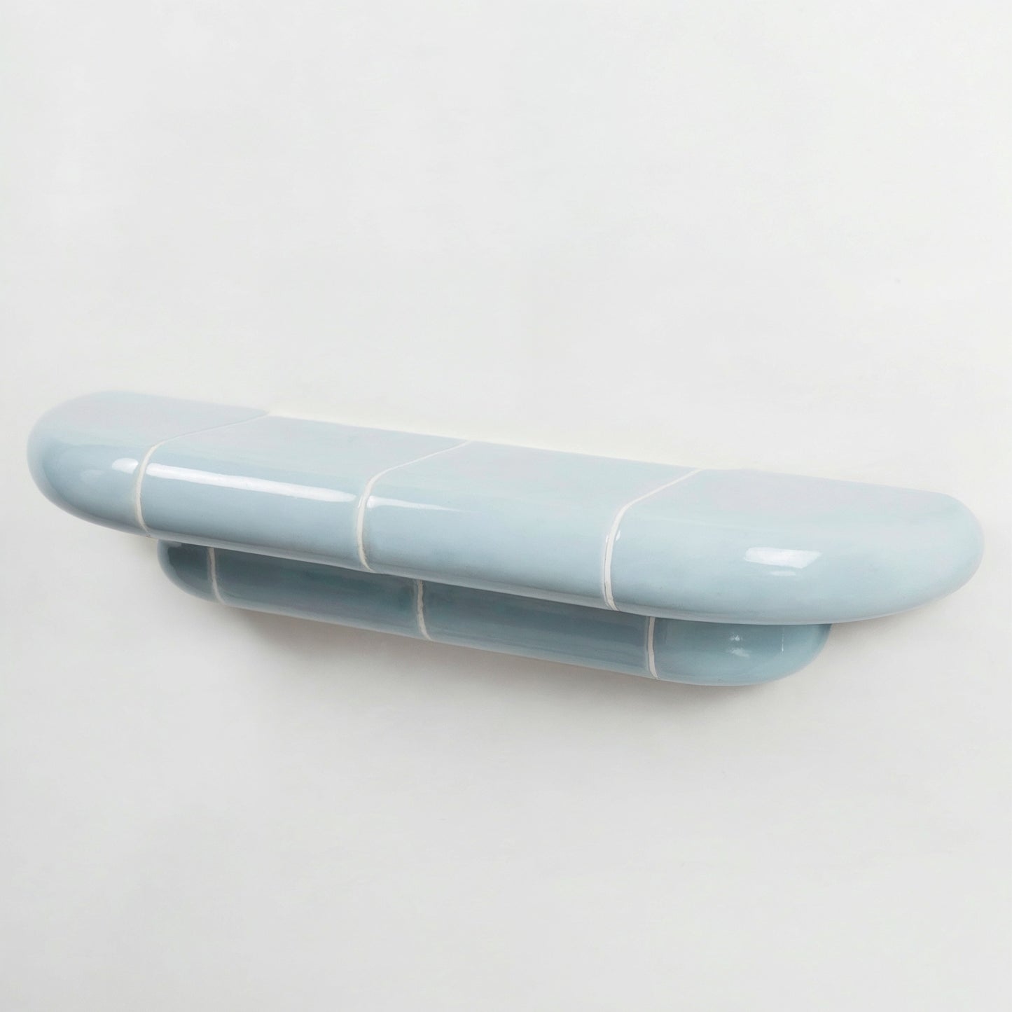 Orbi floating wall shelf in glossy Ice Blue finish, handcrafted in Spain.