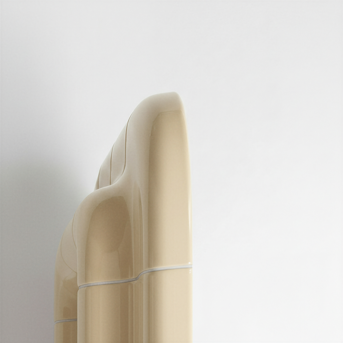 Detailed side profile of a Soft Butter ceramic-look mirror, emphasizing its sculptural thickness and curved geometry.