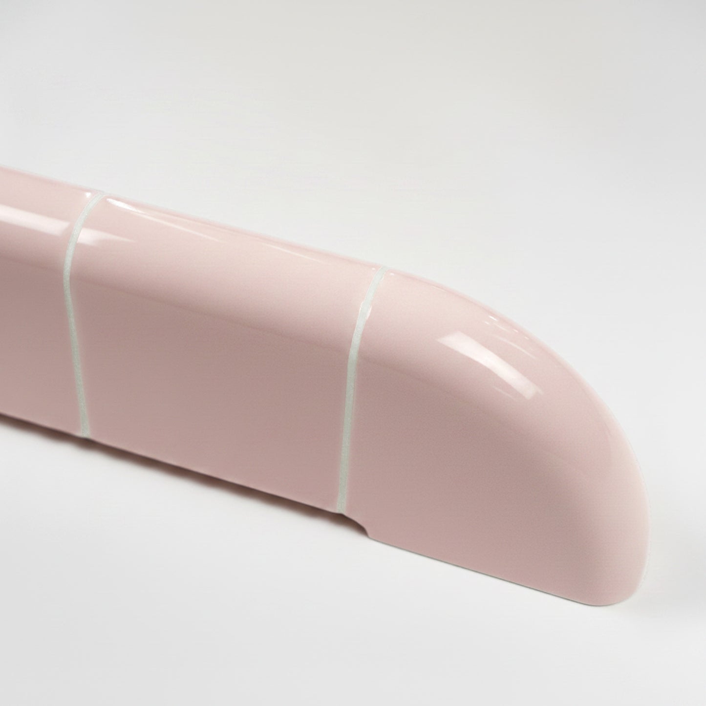 Close-up of the Orbi shelf in glossy Blush Pink, highlighting its smooth rounded edges and ceramic-inspired craftsmanship.