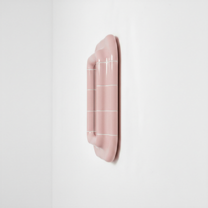 Side view of the blush pink ceramic-look mirror showing its depth and curved frame.