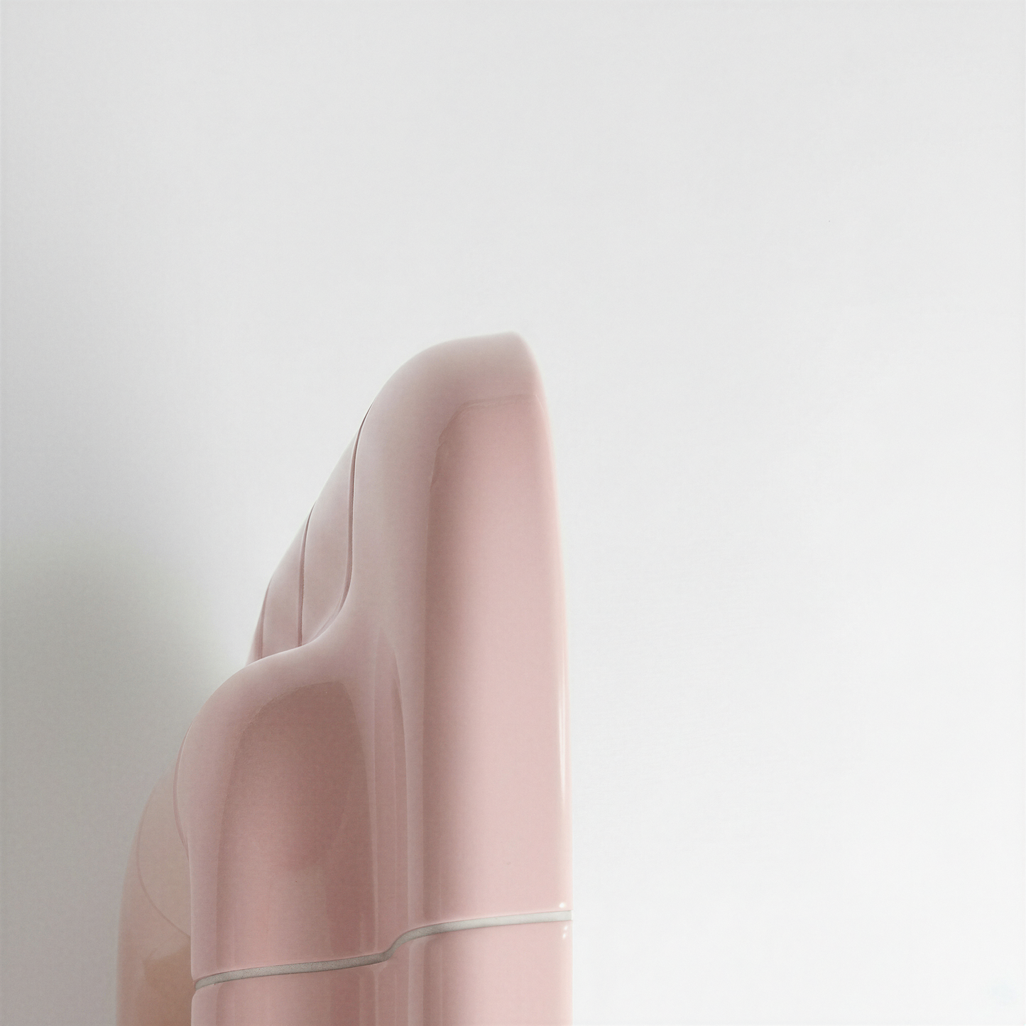 Rear angle view highlighting the sculptural volume of the blush pink mirror frame.