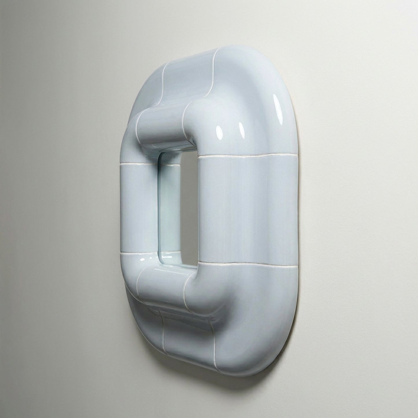 Profile view of Lolo mirror in Ice Blue by Tilecito, deep sculptural frame with glossy ceramic-look finish mounted on wall
