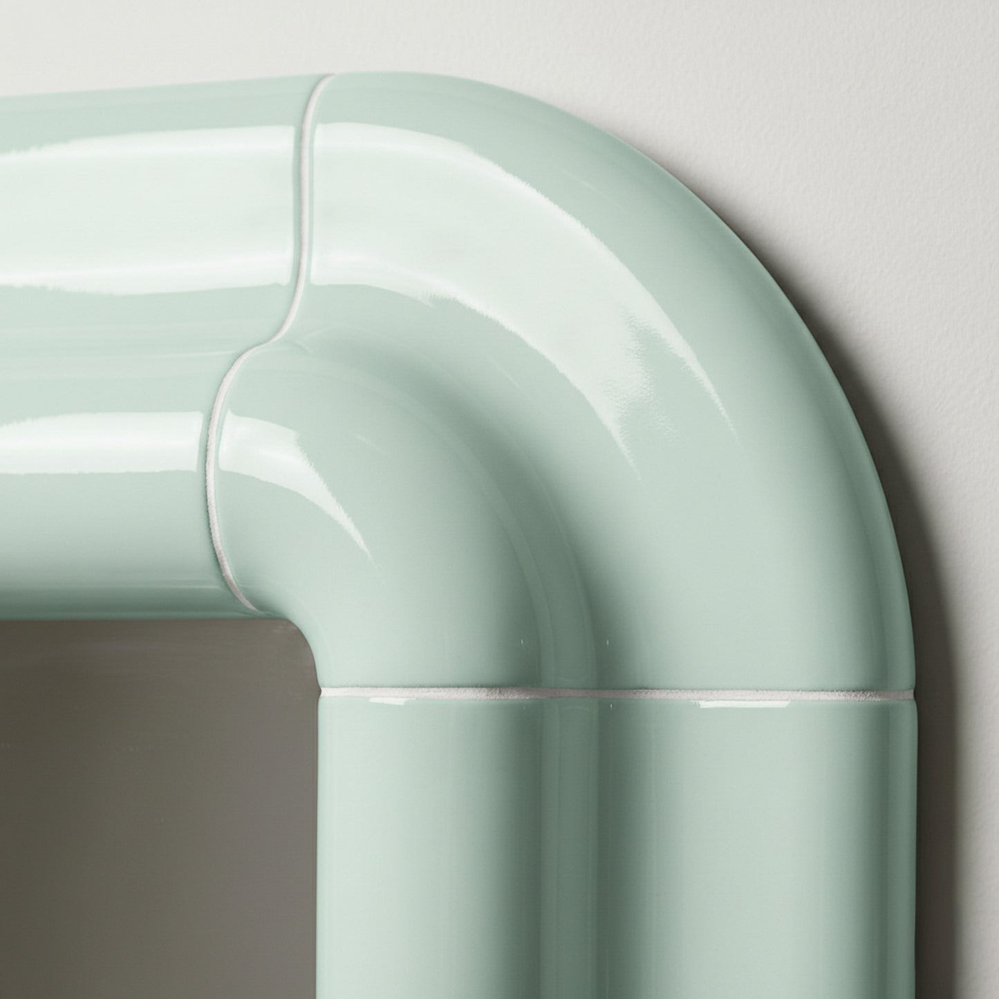 Detail of Lolo mirror in Pastel Mint by Tilecito, rounded corner with glossy tile-inspired finish and visible grout-style lines