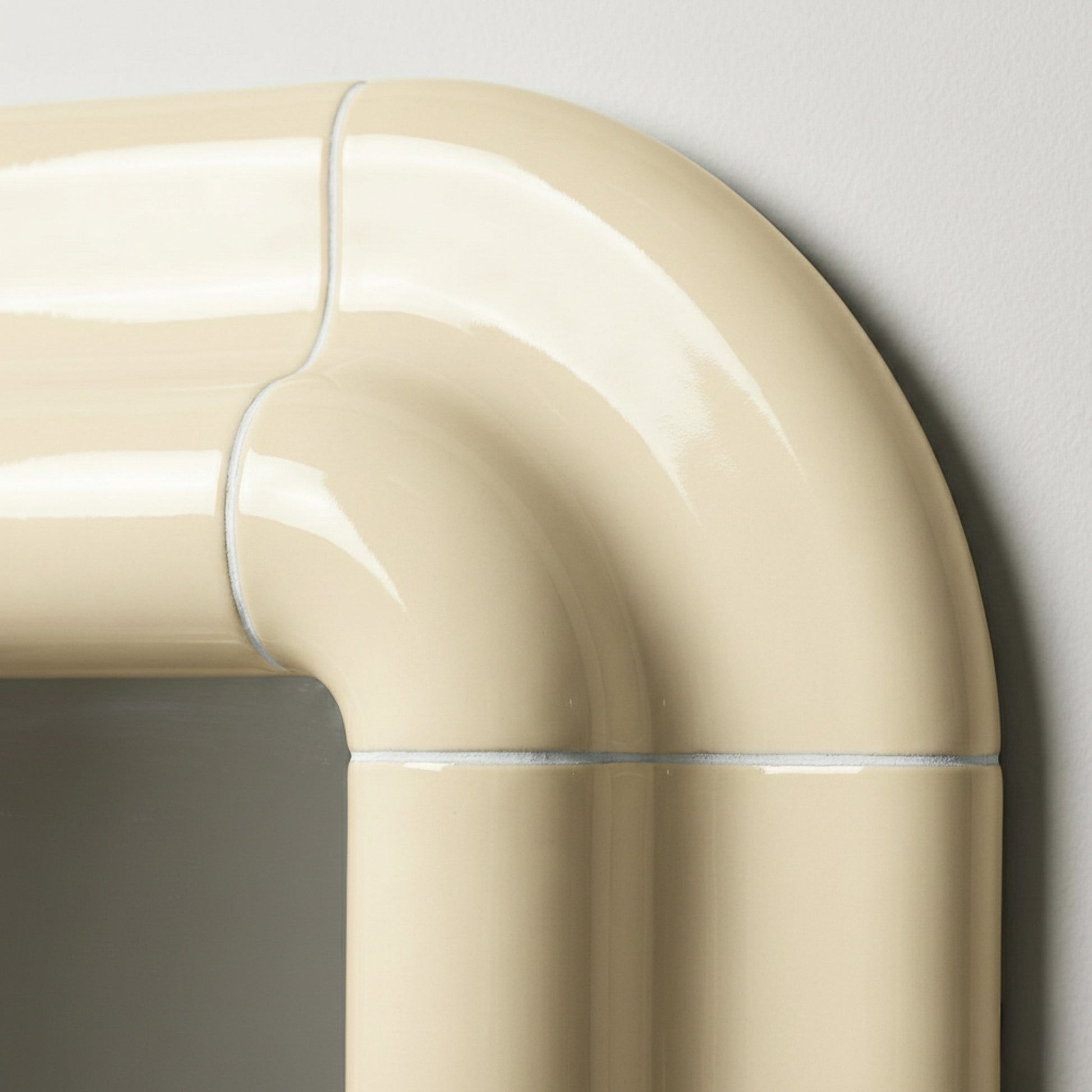 Detail of Lolo ceramic mirror in Soft Beige by Tilecito, rounded glazed tile corner with visible grout lines and high-gloss finish