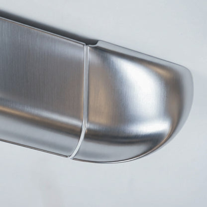 Detail of the Orbi shelf's curved end module, showing the high-gloss silver lacquer and white joint line